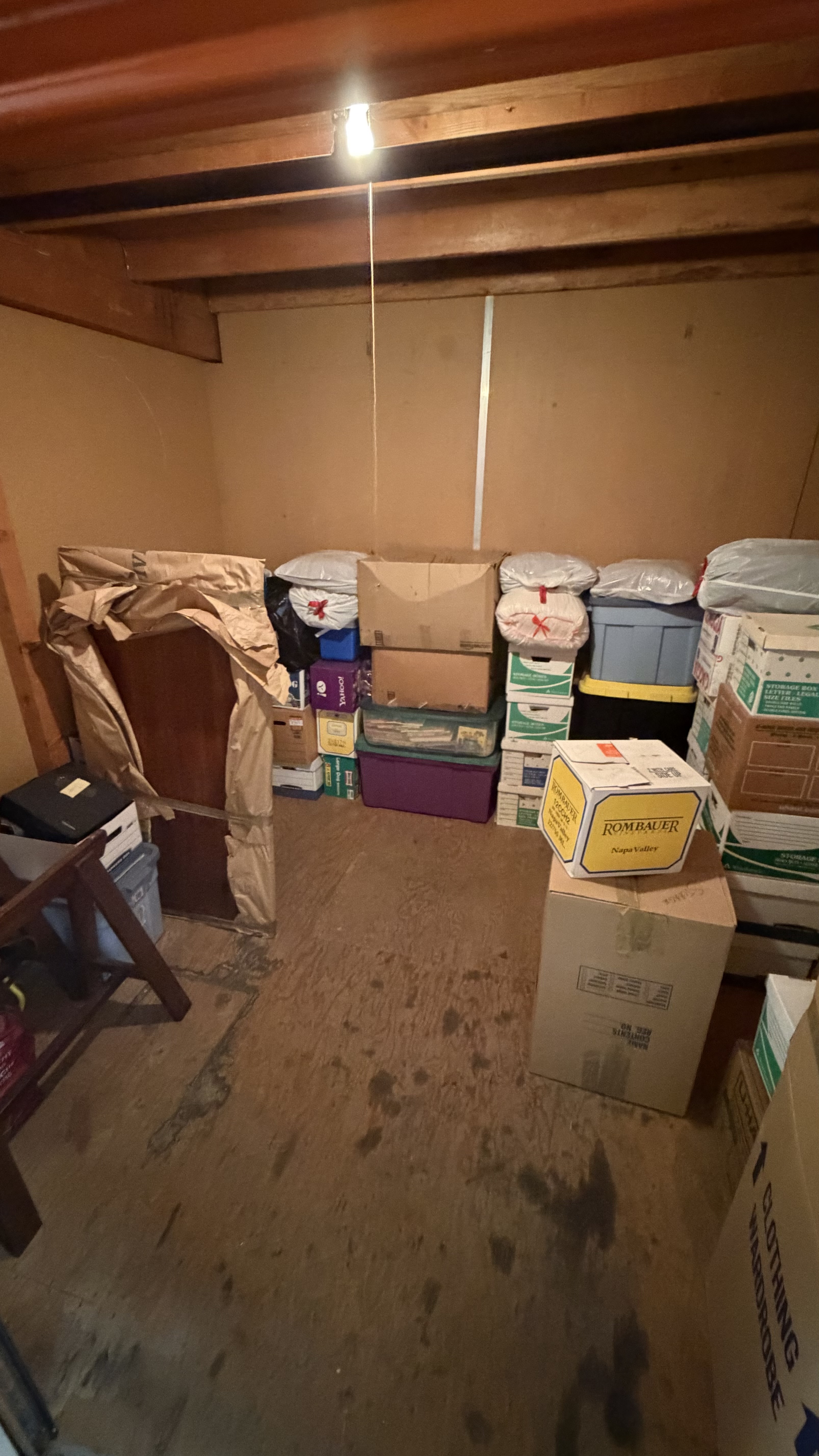 Before — storage space packed with boxes and bins